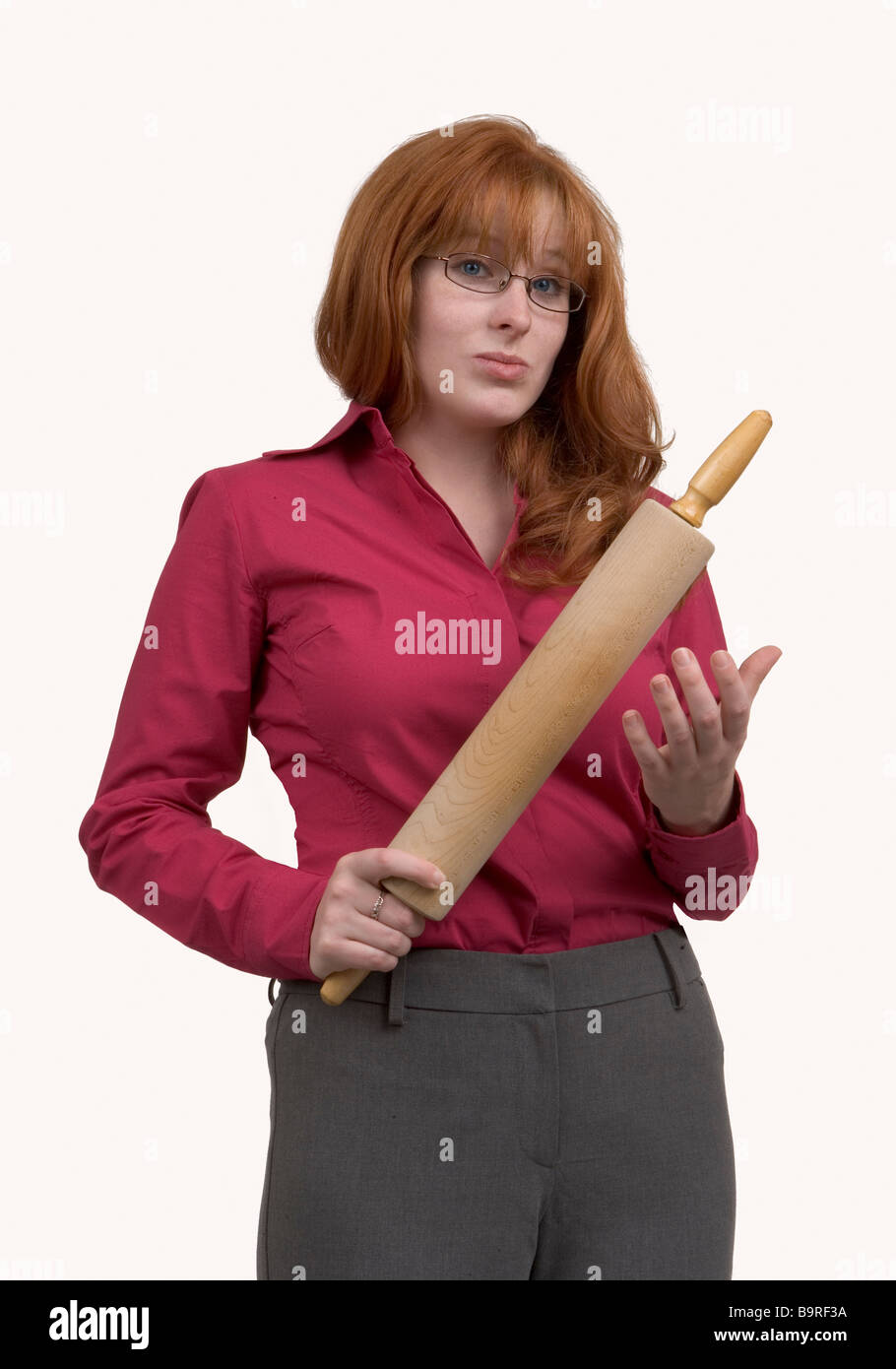 Une femme rousse en colère avec un rouleau à pâtisserie en bois spéléologie dans une manière menaçante Banque D'Images