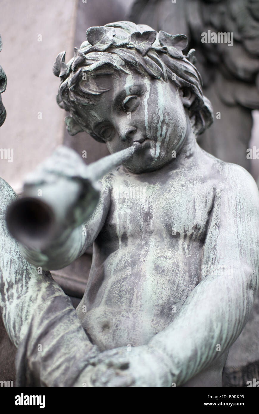 Une sculpture en pierre d'un enfant qui joue sur une flûte Banque D'Images