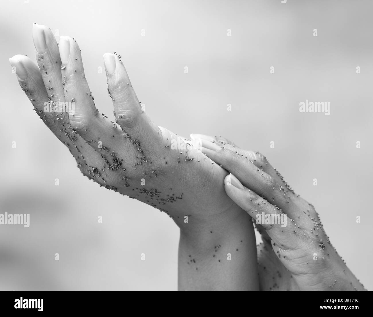 Paire de mains frottant en exfoliant au cours d'un traitement de beauté Banque D'Images