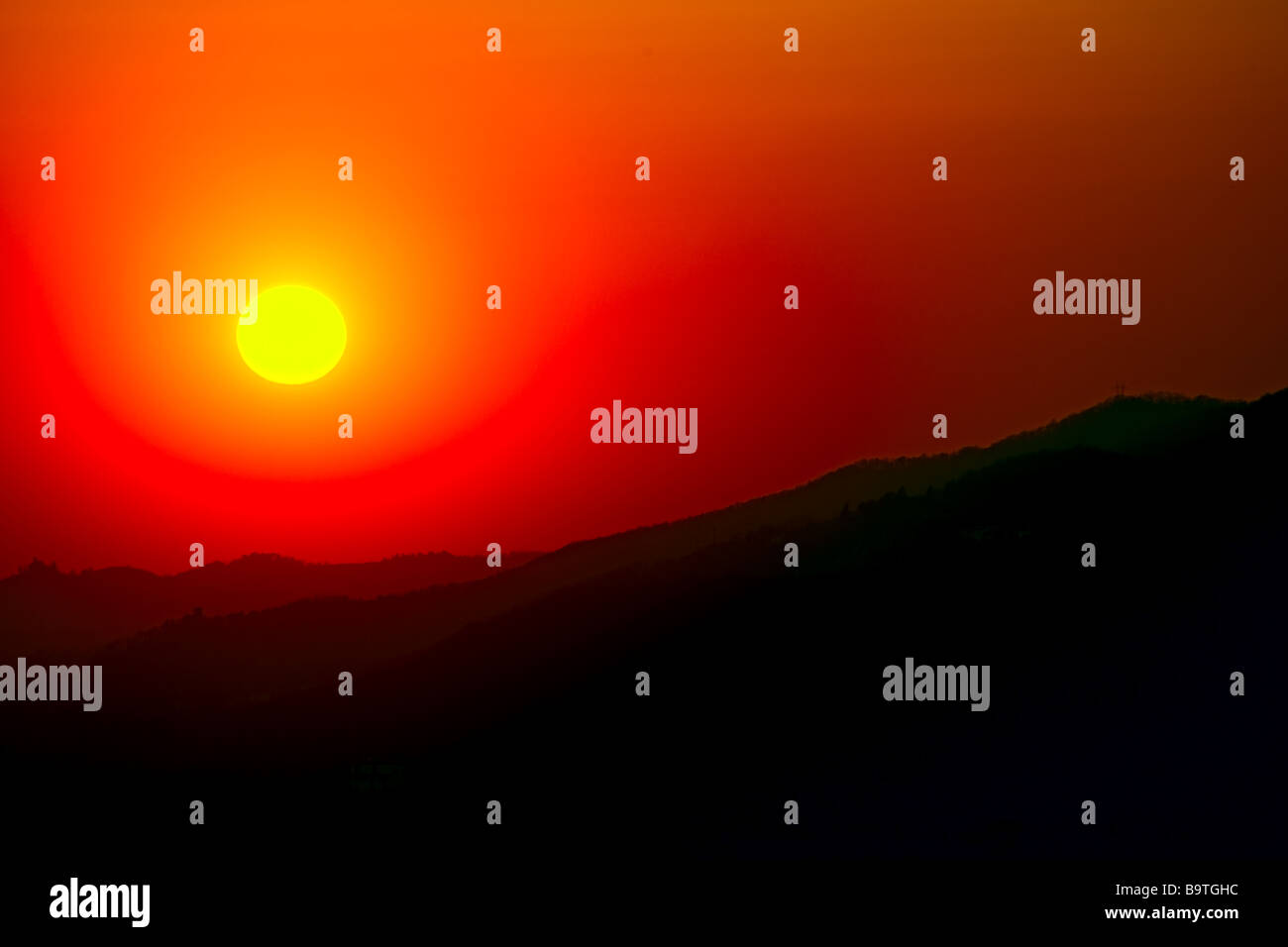 Coucher du soleil sur la lointaine silhouette de la crête d'une chaîne de collines Banque D'Images