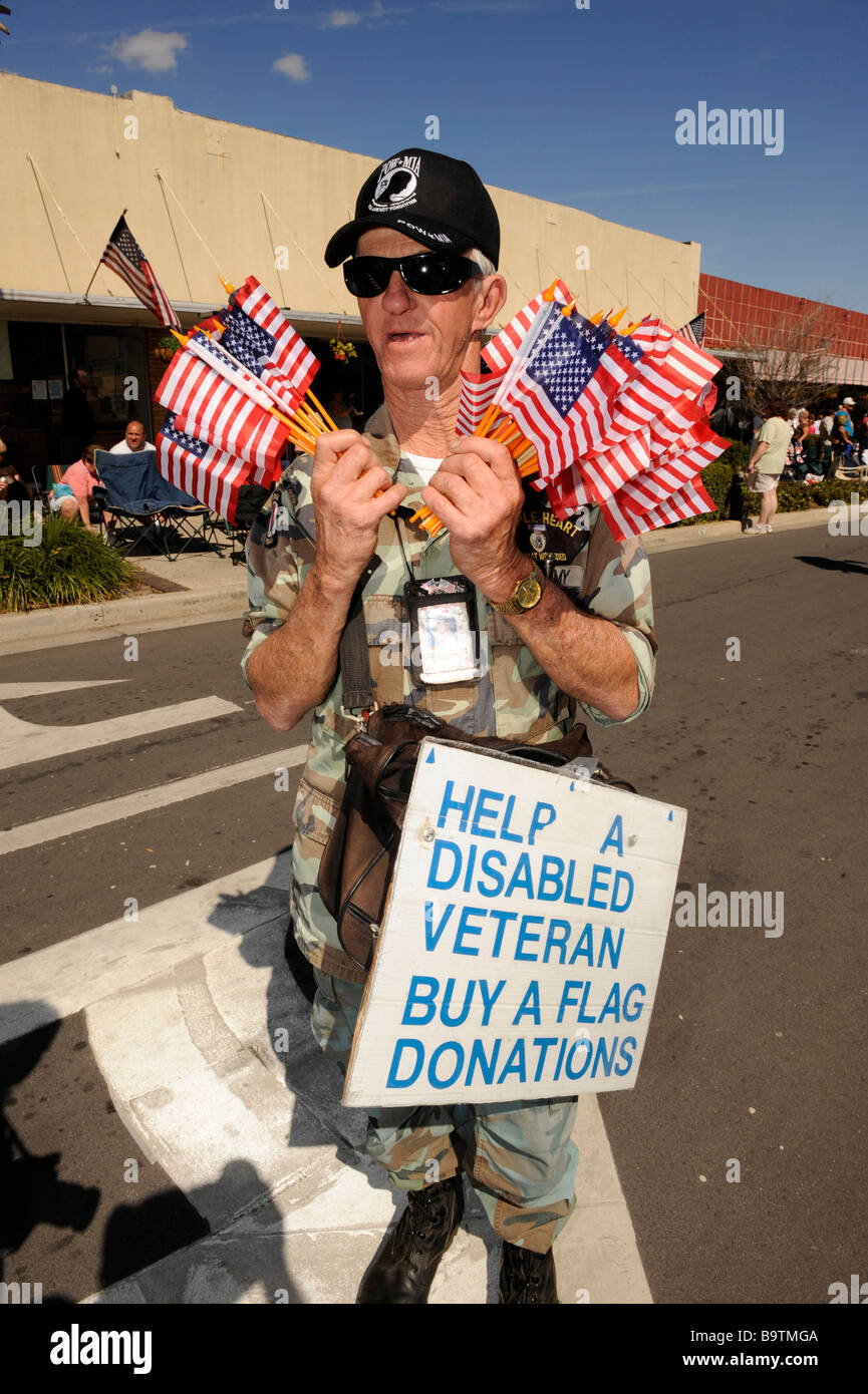Homme de race blanche Mobilité Army Veteran vend les drapeaux à Lake Wales Mardi Gras Central Florida United States Banque D'Images