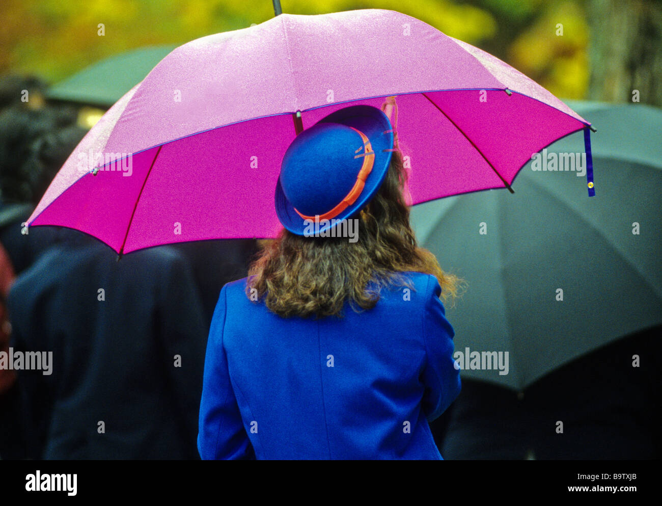 Guide des femmes en uniforme bleu attend avec un parapluie au Parc de la paix de Hiroshima Hiroshima Japon Banque D'Images
