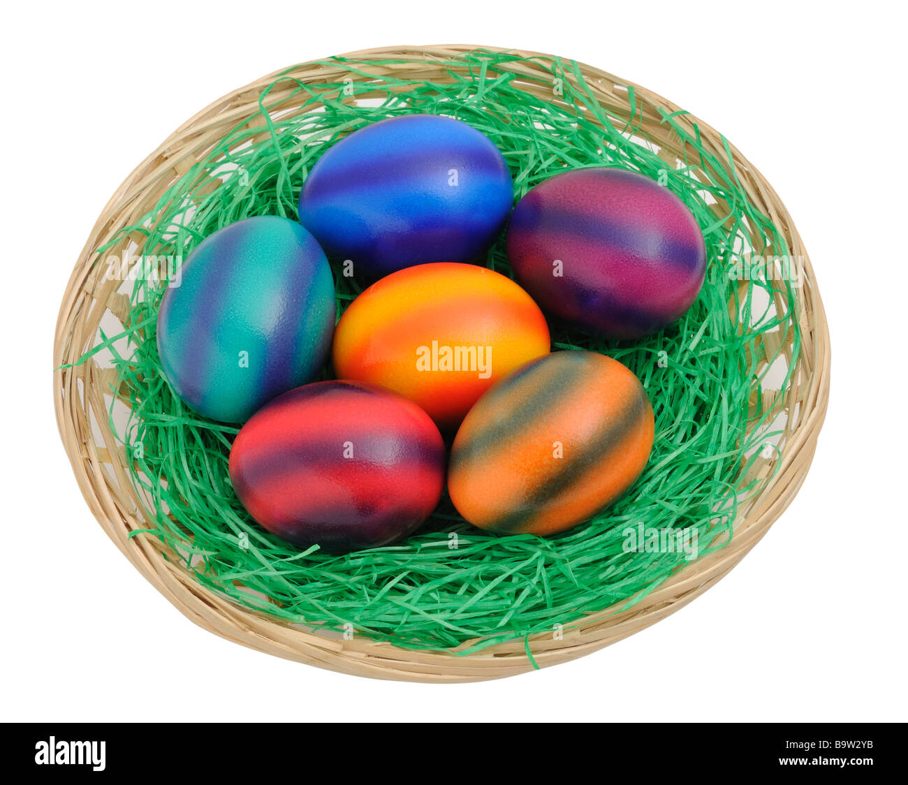 Les oeufs de Pâques colorés dans un nid isolé sur fond blanc Banque D'Images