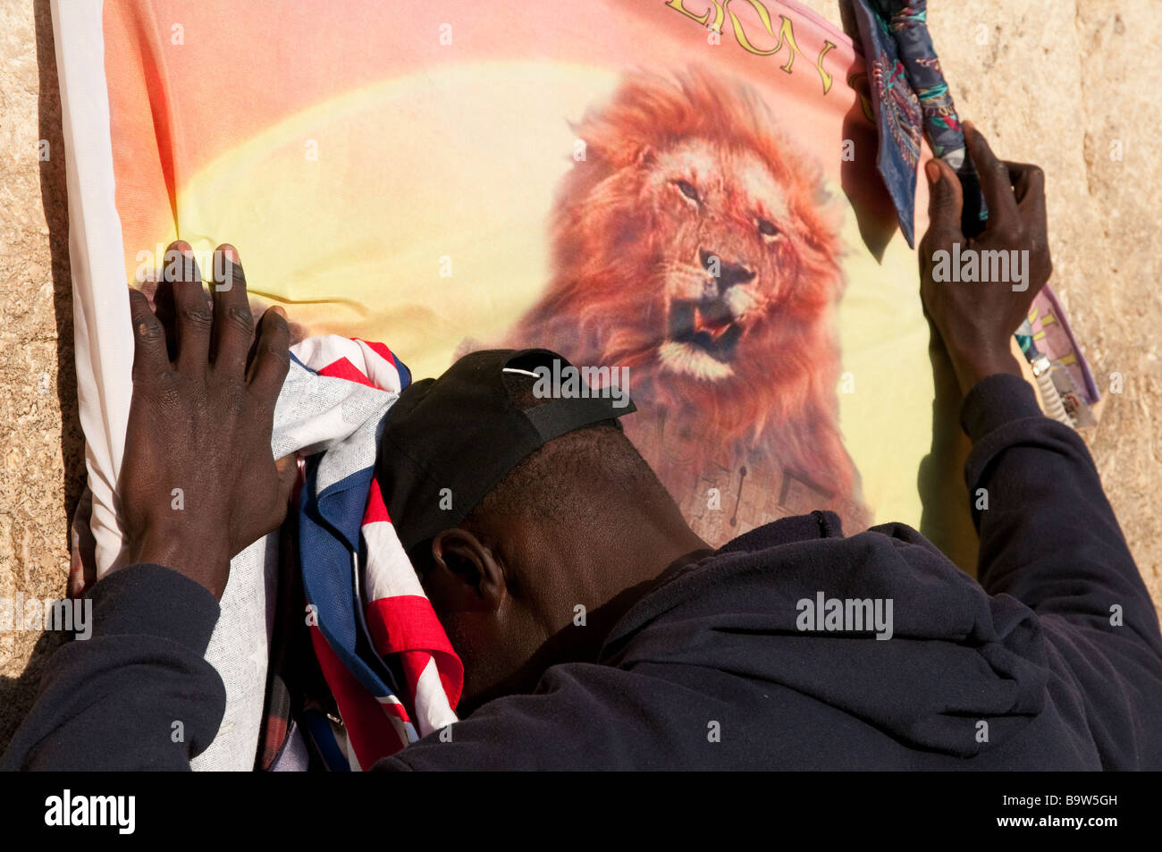 Israël Jérusalem Vieille Ville mur Ouest Close up of African man priant au mur avec lion sur le drapeau Banque D'Images