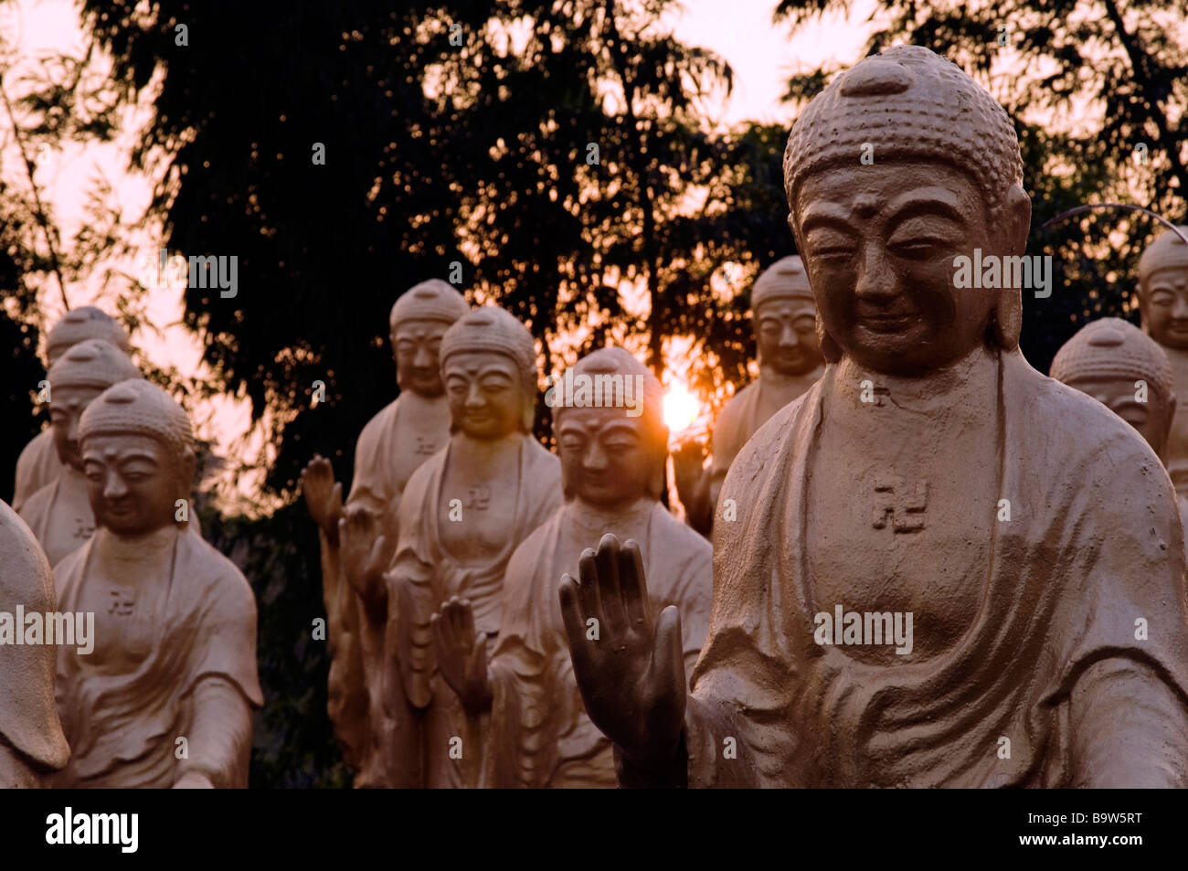 Groupe de statues de Bouddha, les mains étendues et soleil derrière les Fokuangshan (Lumière de montagne de Bouddha) à Taiwan Banque D'Images