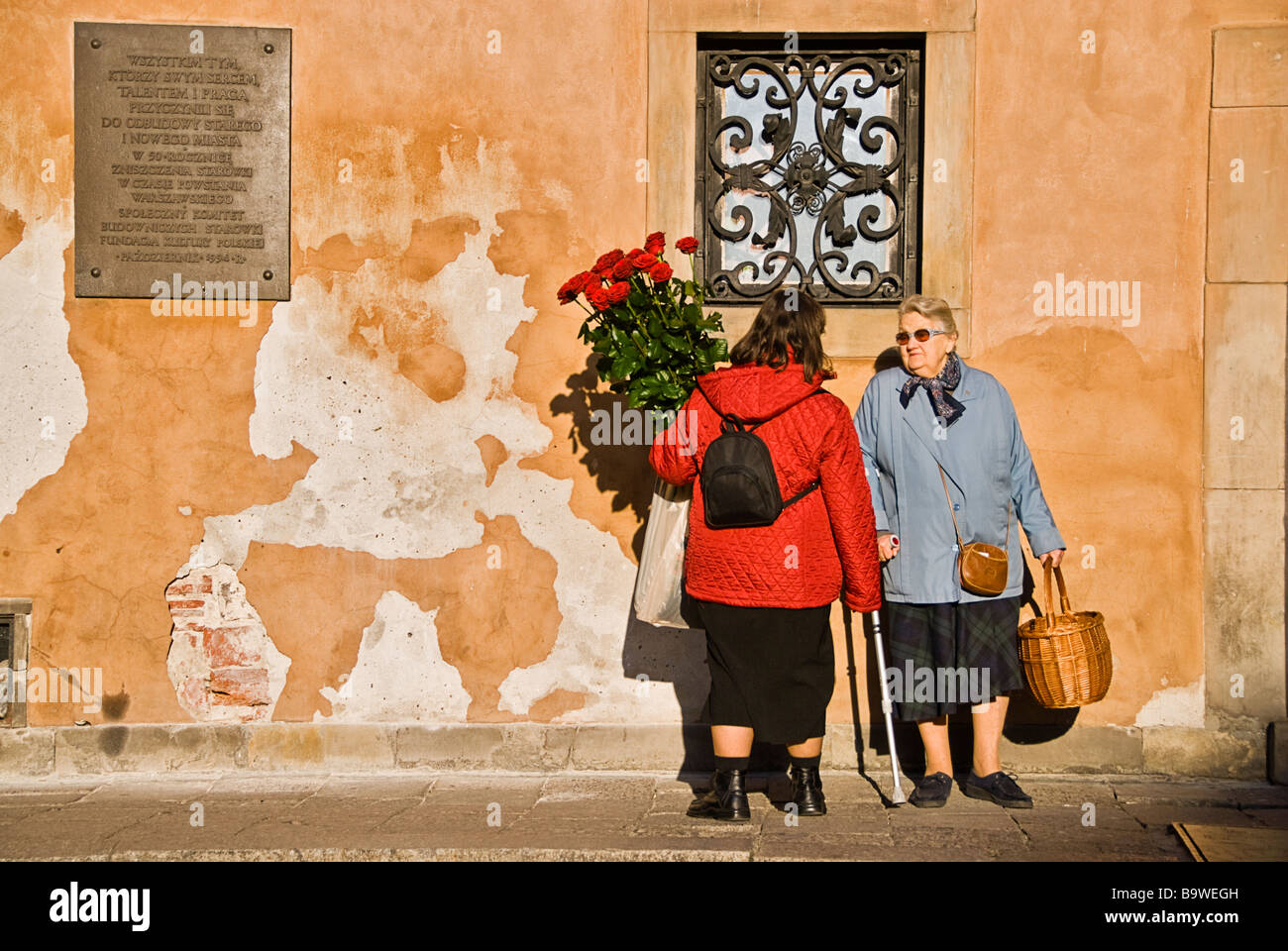 Les femmes avec des fleurs en pleine discussion dans les rues de la vieille ville de Varsovie, Pologne, Europe. Banque D'Images