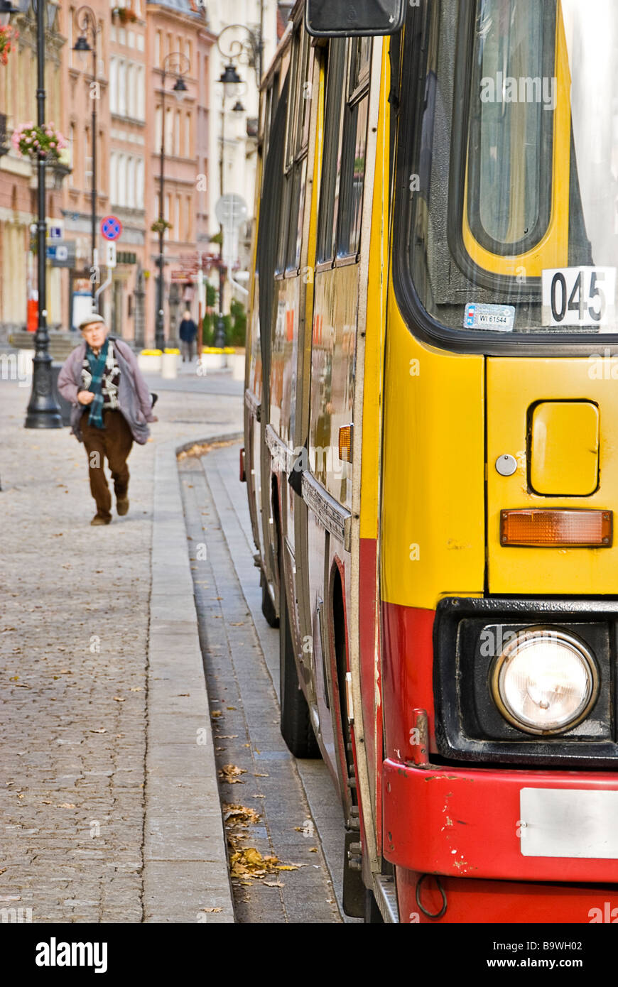 Homme qui court pour attraper le bus dans les rues de Varsovie, Pologne, Europe. Banque D'Images