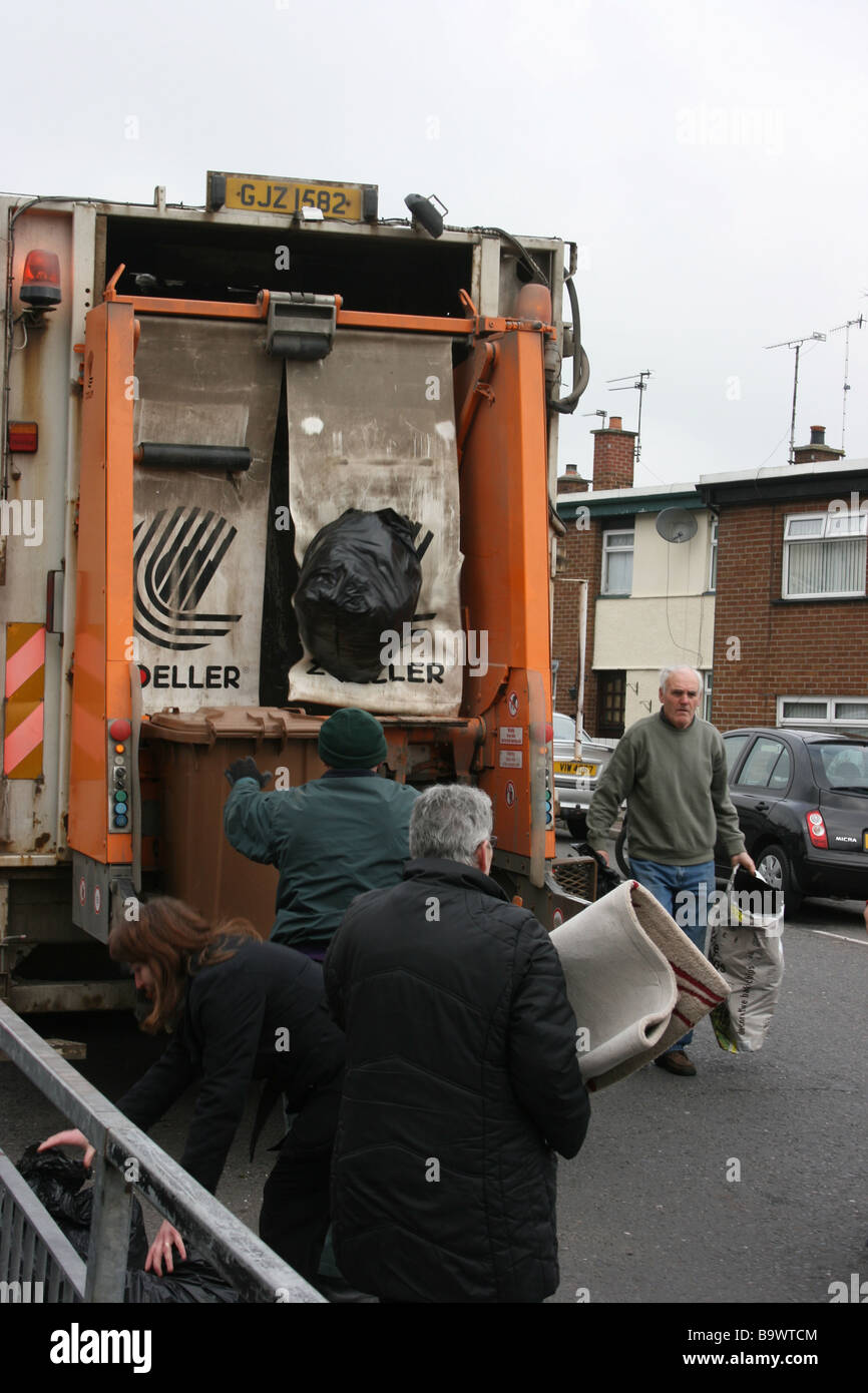 Les personnes apportant leurs déchets à un camion poubelle dans la rue, Killyleagh Castle, en Irlande du Nord Banque D'Images