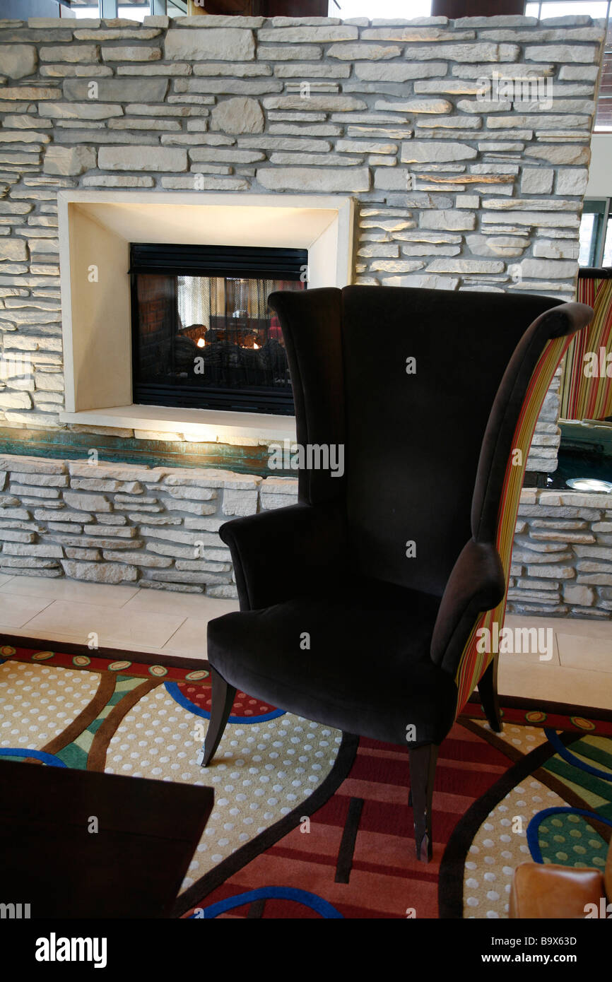 Générique siège fauteuil lobby cheminée en pierre table books accueil chaleureux Banque D'Images