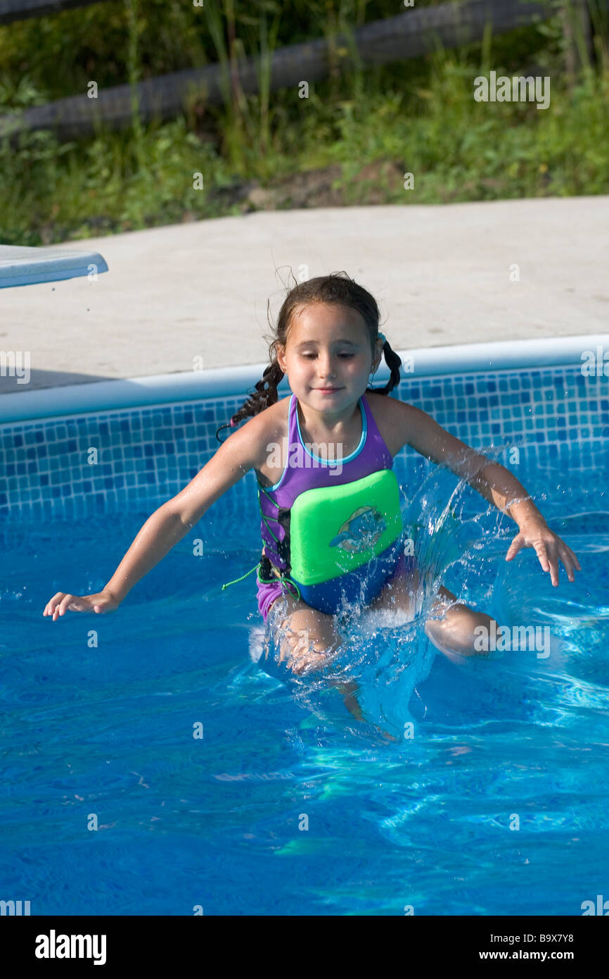 5 ans, fille de sauter dans une piscine de plongée Banque D'Images