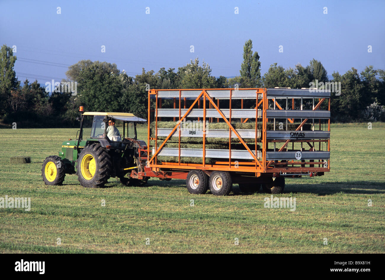 Le tracteur la collecte des balles de foin, vallée de la Durance, Provence, France Banque D'Images