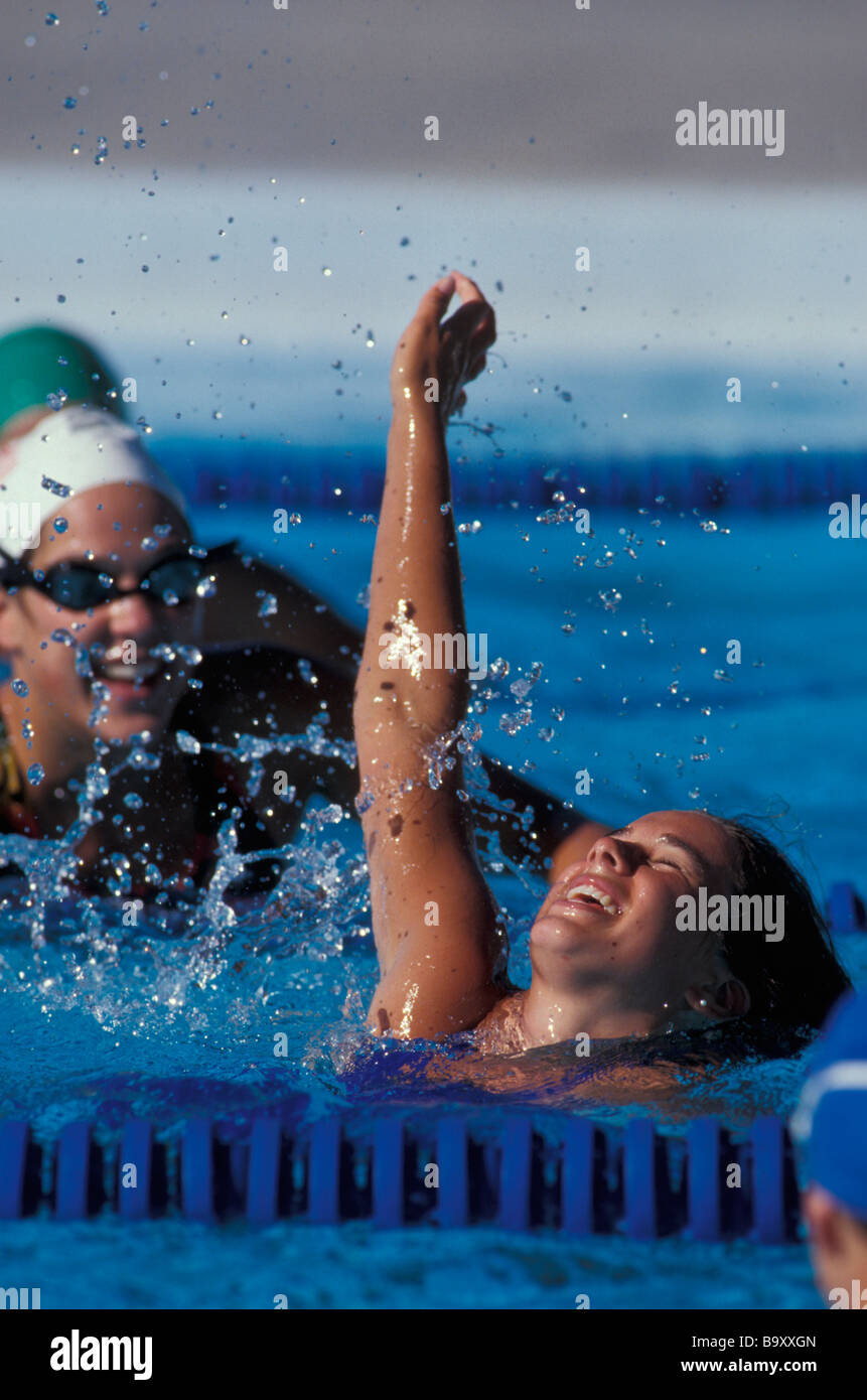 Femme célèbre sa victoire dans la course de natation Banque D'Images