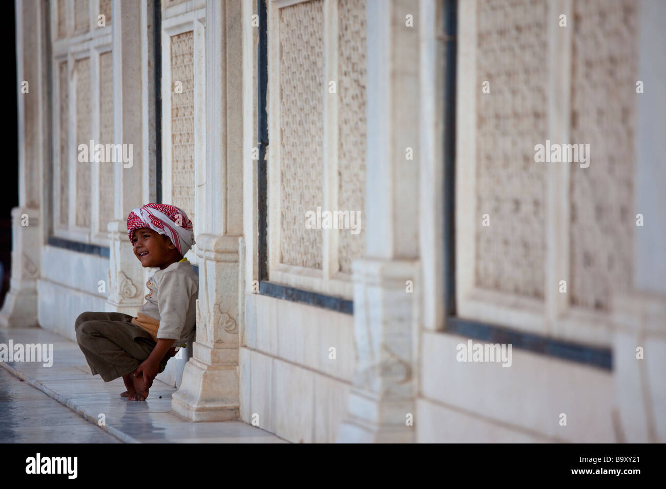 Jeune Indien portant un keffieh à côté du culte dans la mosquée de vendredi à Fatehpur Sikri Inde Banque D'Images