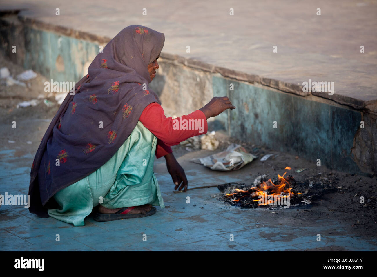 Réchauffement de la femme à côté de détritus incendie dans Delhi Inde Banque D'Images