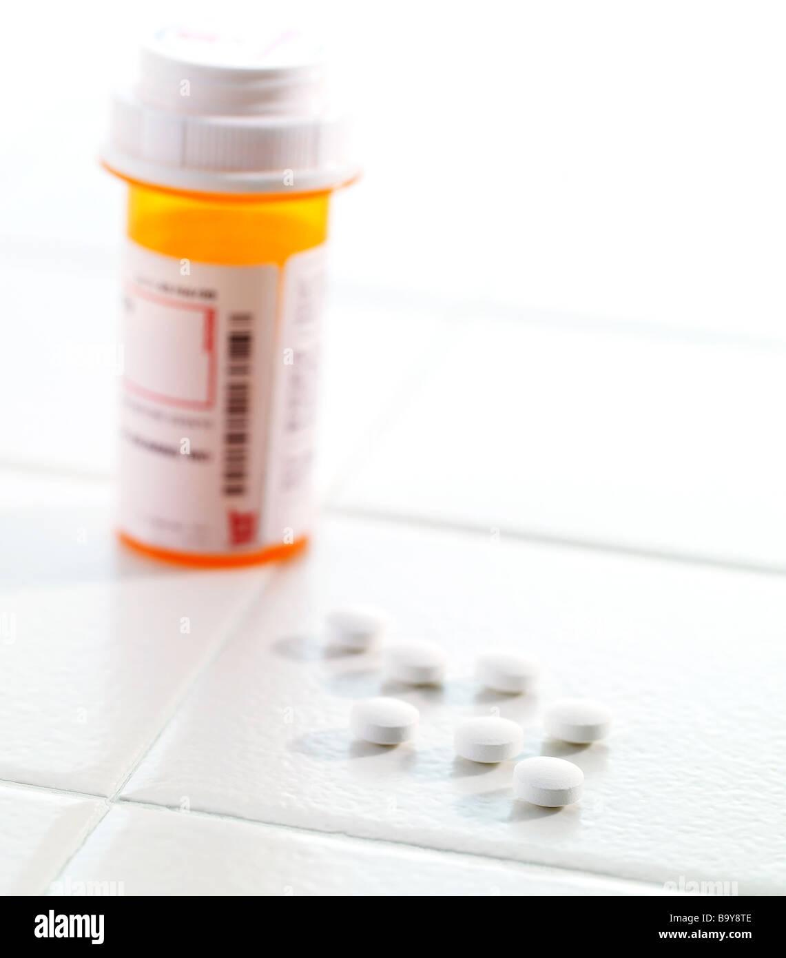 Bouteille de pilules avec des comprimés à renversé sur une surface de carreaux Banque D'Images