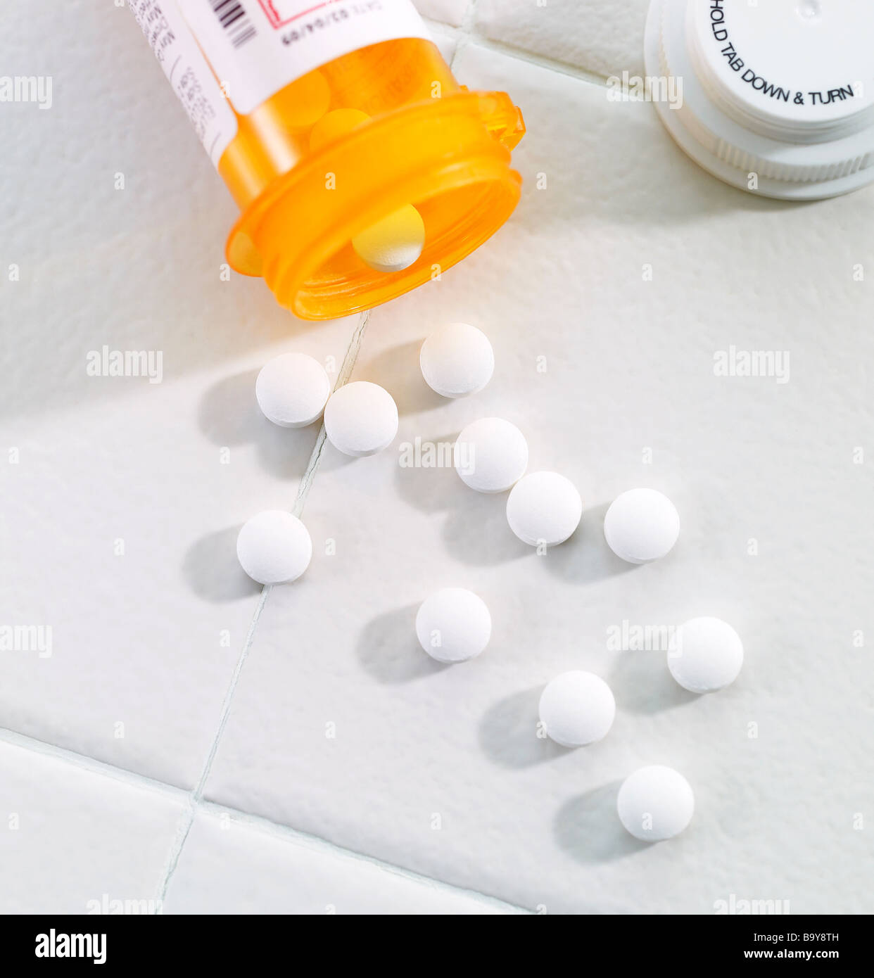 Bouteille de pilules avec des comprimés à renversé sur une surface de carreaux Banque D'Images