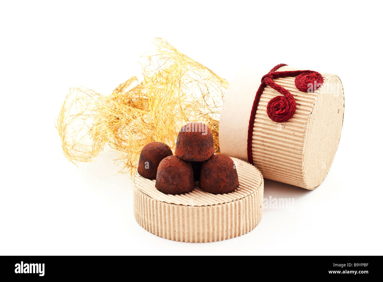 Truffes à la main sur une couverture de carton cadeau fond blanc Banque D'Images