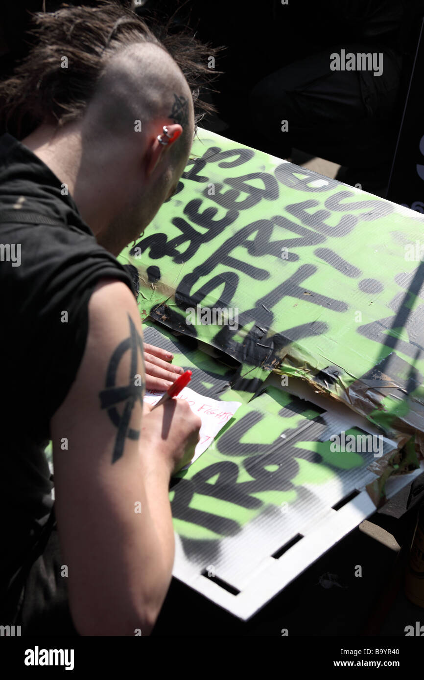 Manifestant de l'écriture d'un message sur une carte à l'extérieur de la Banque d'Angleterre au cours de la 2009 Sommet du G20, Londres, Royaume-Uni. Banque D'Images