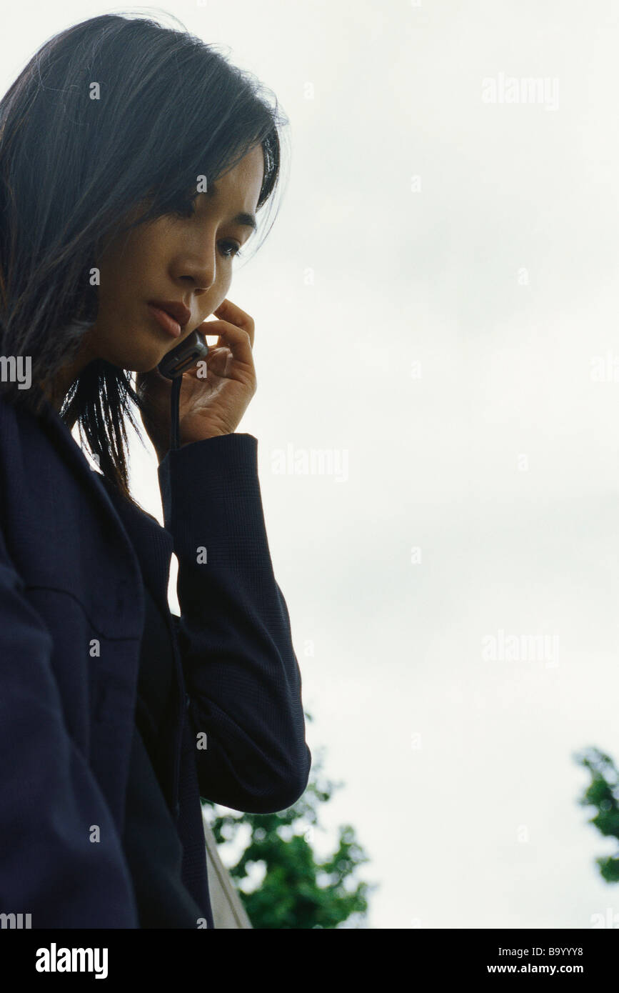 Woman using cell phone outdoors, low angle view Banque D'Images