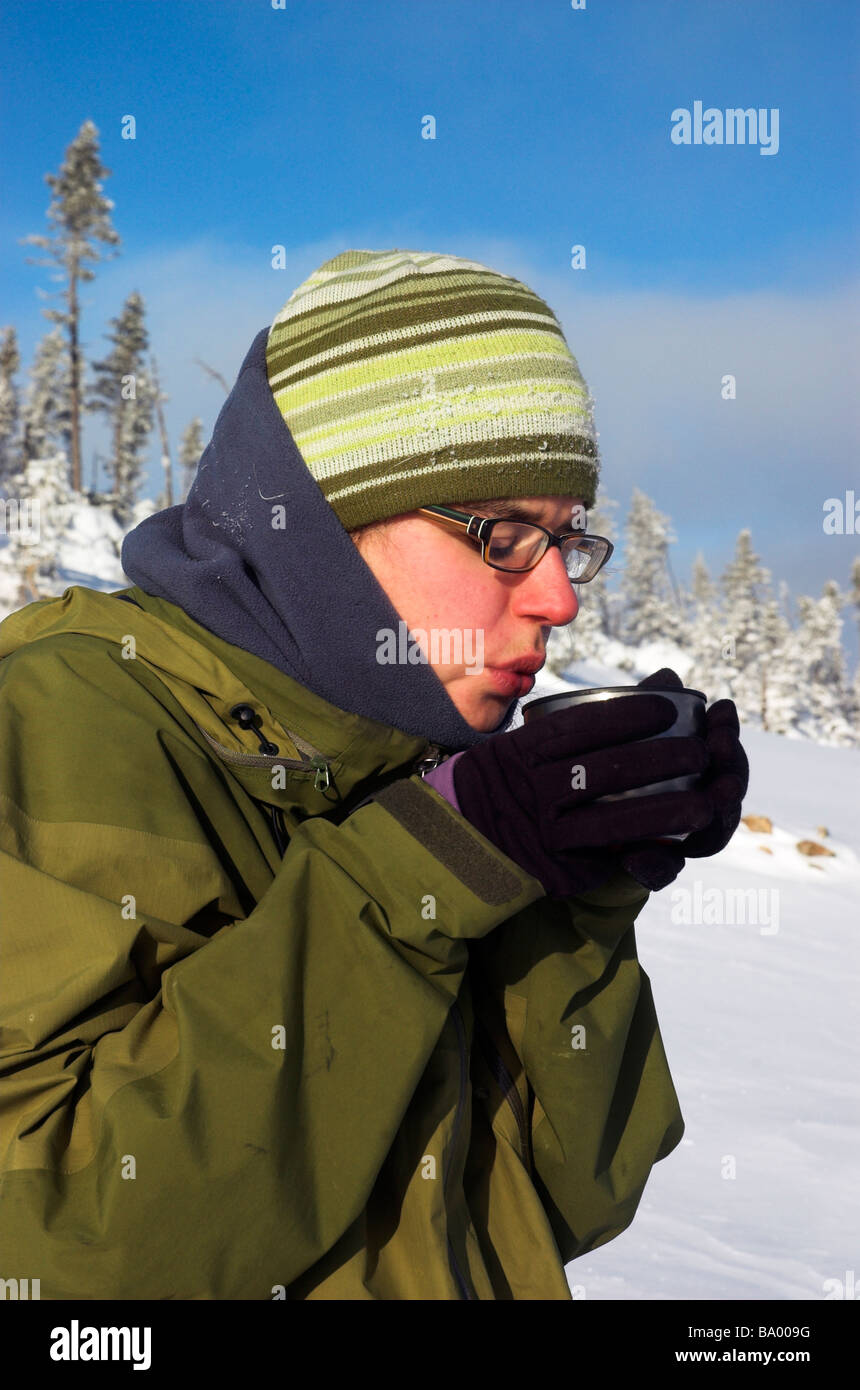Une femme à boire le thé à partir d'un ballon dans l'hiver du Québec Banque D'Images