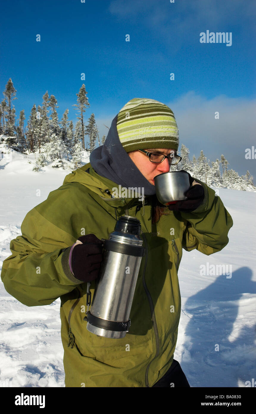 Une femme à boire le thé à partir d'un ballon dans l'hiver du Québec Banque D'Images