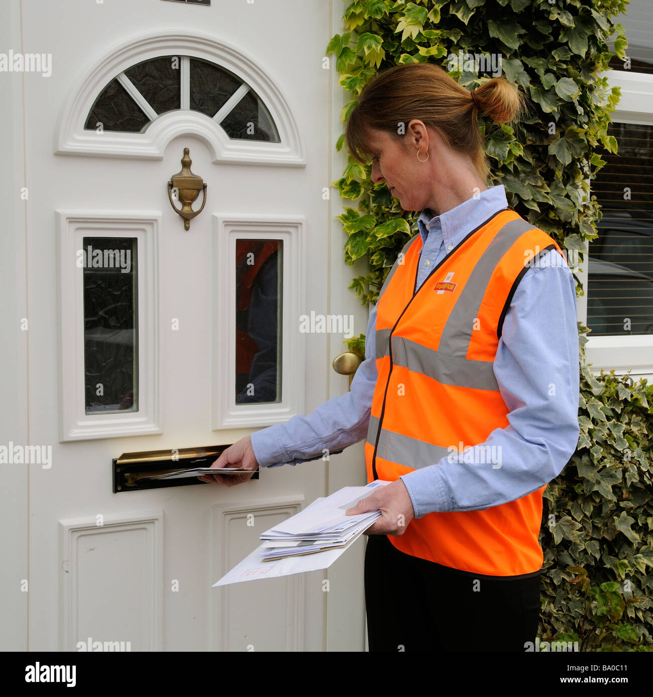 Royal Mail factrice à la porte d'une maison la distribution du courrier à un client Banque D'Images