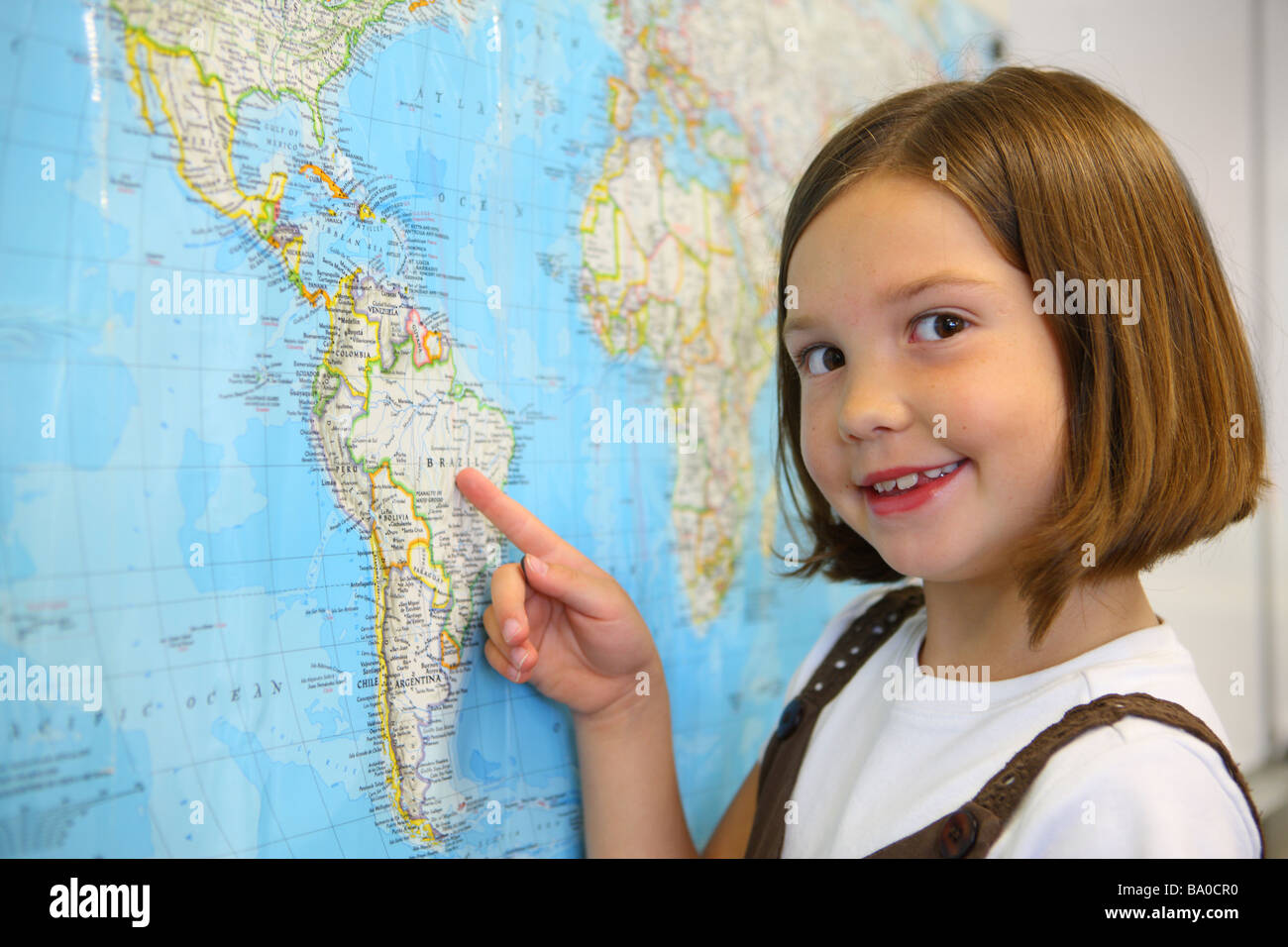 School girl pointing de pays sur la carte Banque D'Images
