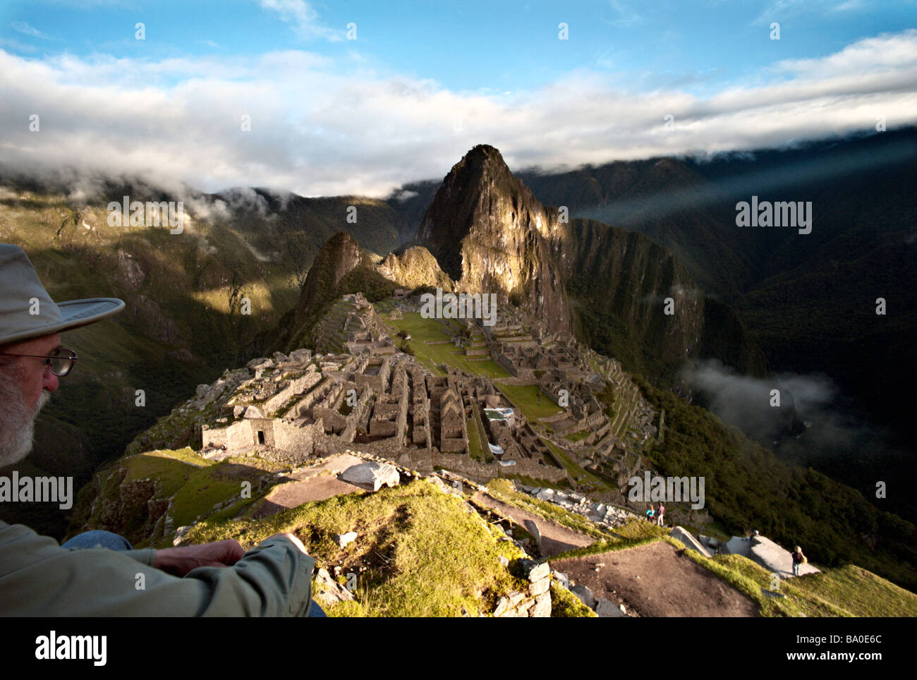 Pérou MACHU PICCHU montres touristiques le soleil percer les nuages au lever du soleil à partir de l'affichage classique du Machu Picchu Banque D'Images