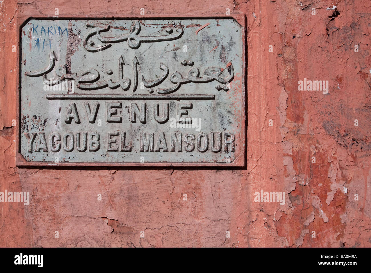 Plaque de rue plaque en fonte en arabe et français intégré dans le mur medina marquant l'avenue Mohammed V, Marrakech Banque D'Images