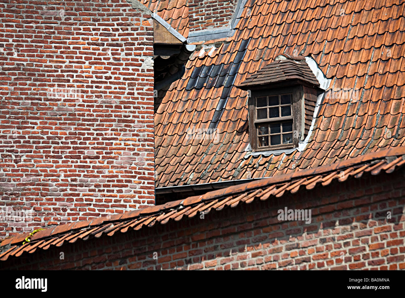 Fenêtre de toit en mansarde avec de vieux murs en brique rouge Tournai Belgique Banque D'Images