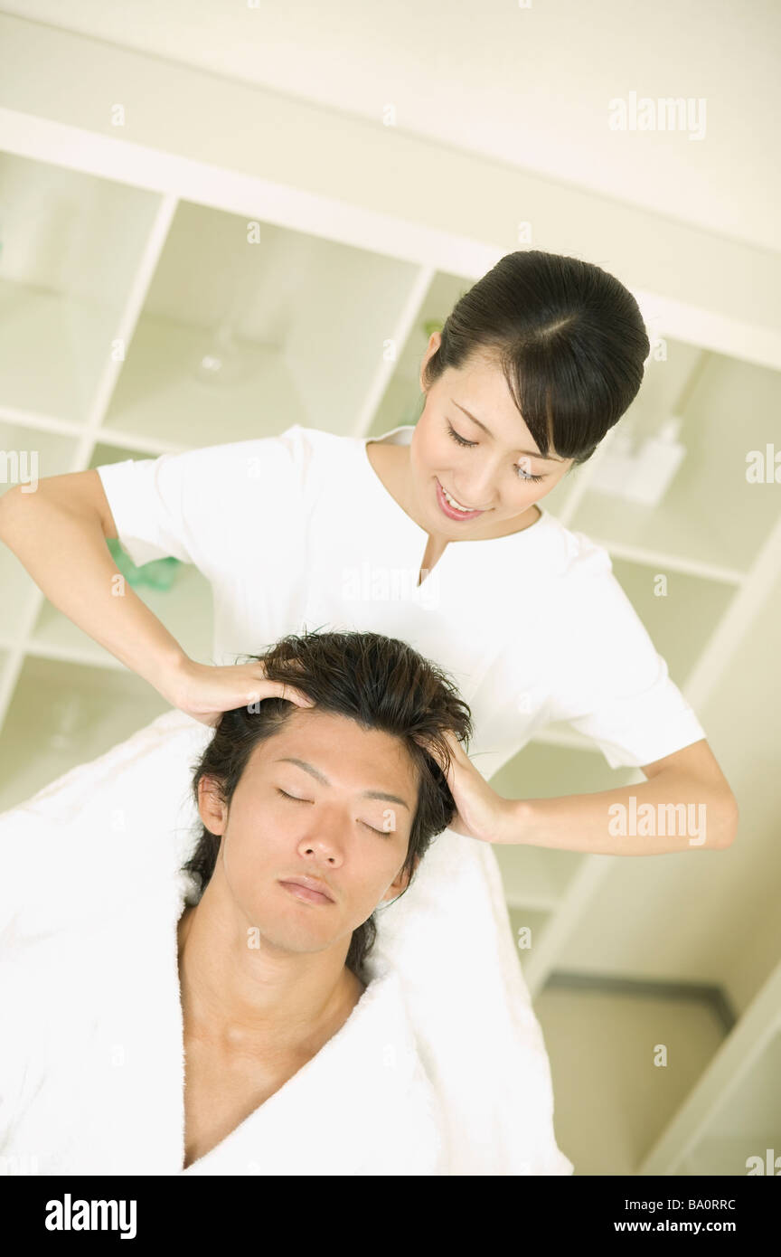 Jeune homme recevant un massage de restauration de cheveux Banque D'Images