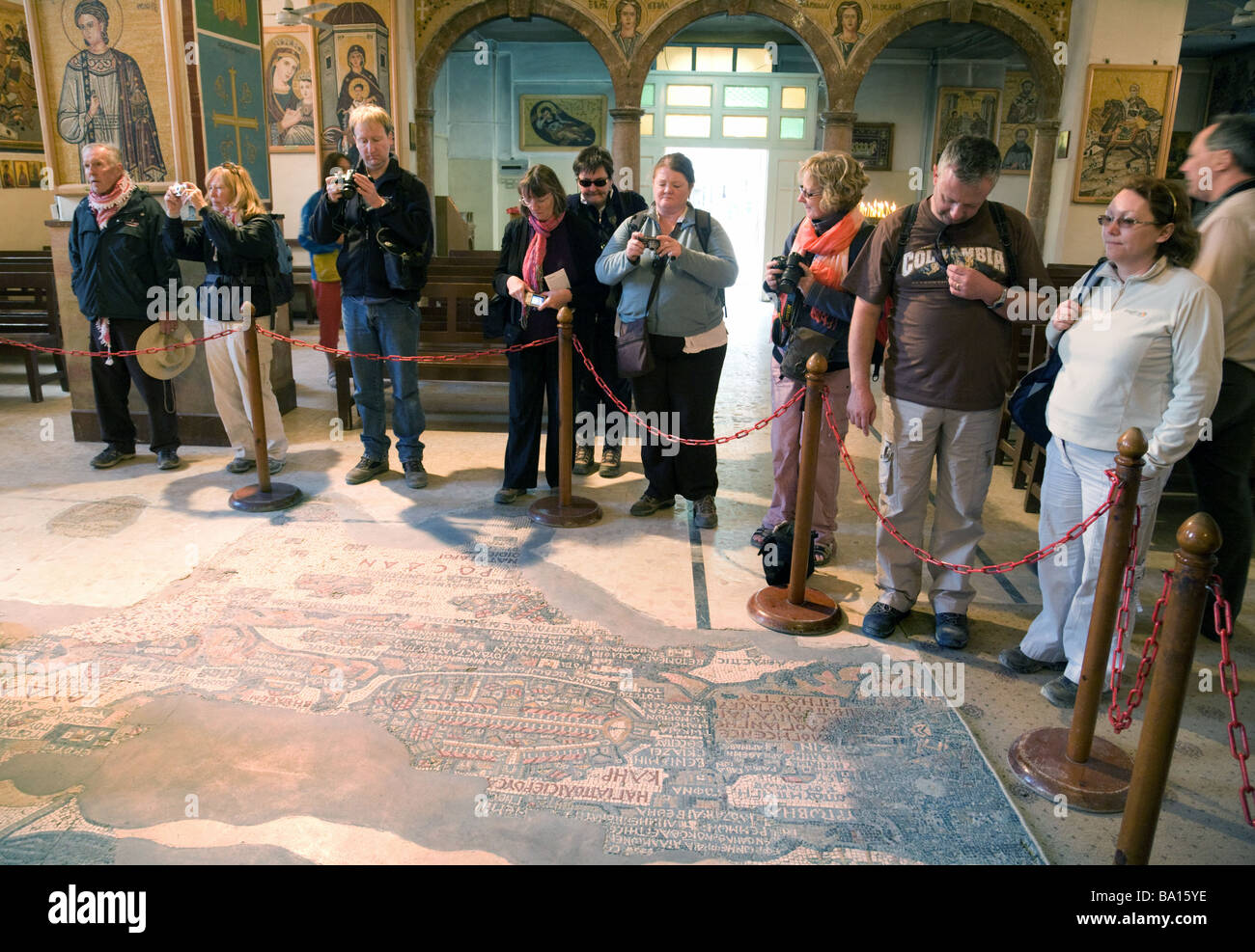 Les touristes à la recherche à la mosaïque de Madaba carte de la Terre Sainte, l'église de St George, Madaba, Jordanie Banque D'Images