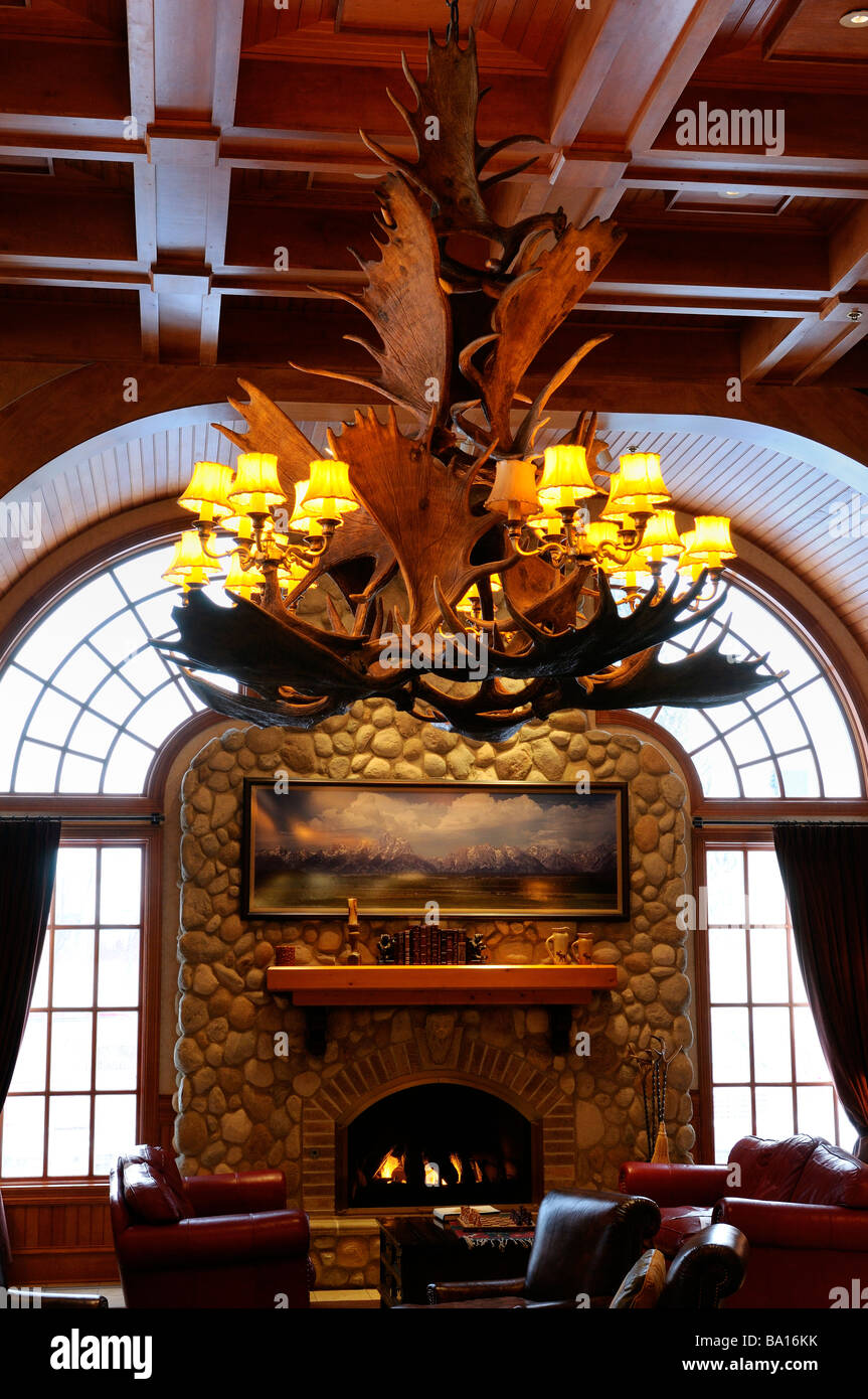 Lustre en bois d'orignal avec cheminée et des fauteuils en cuir de l'ouest dans un lodge Jackson Hole Wyoming Banque D'Images