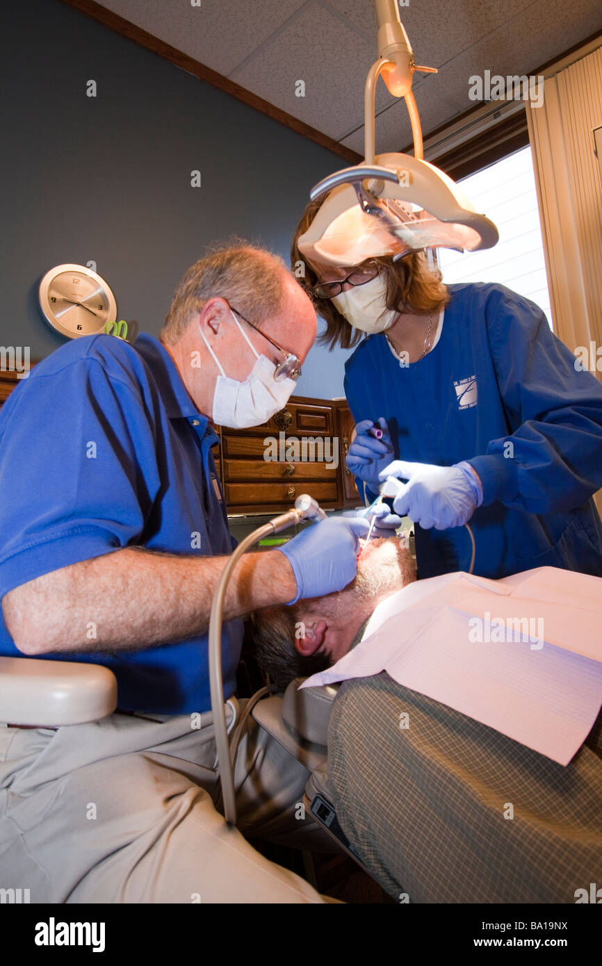 Dentiste et sous-traiter un patient dans un fauteuil de dentiste. Banque D'Images