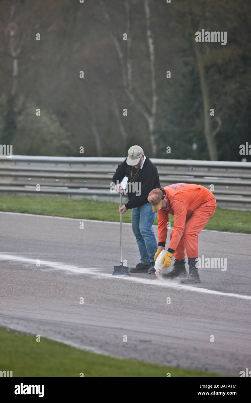 750 Motor Club Formule historique course du championnat junior de la poussière de plâtre est appliqué à la piste par marshalls pour absorber les déversements de pétrole Banque D'Images
