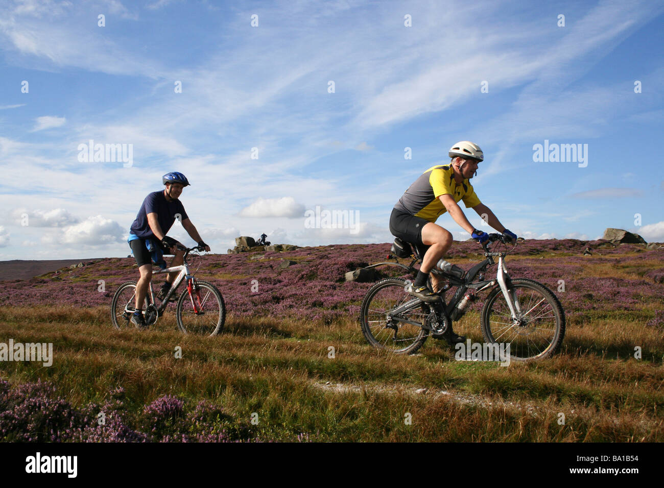 Deux mâles adultes, vélo de montagne équitation sur un large croisement Embsay Moor, Yorkshire Dales Banque D'Images