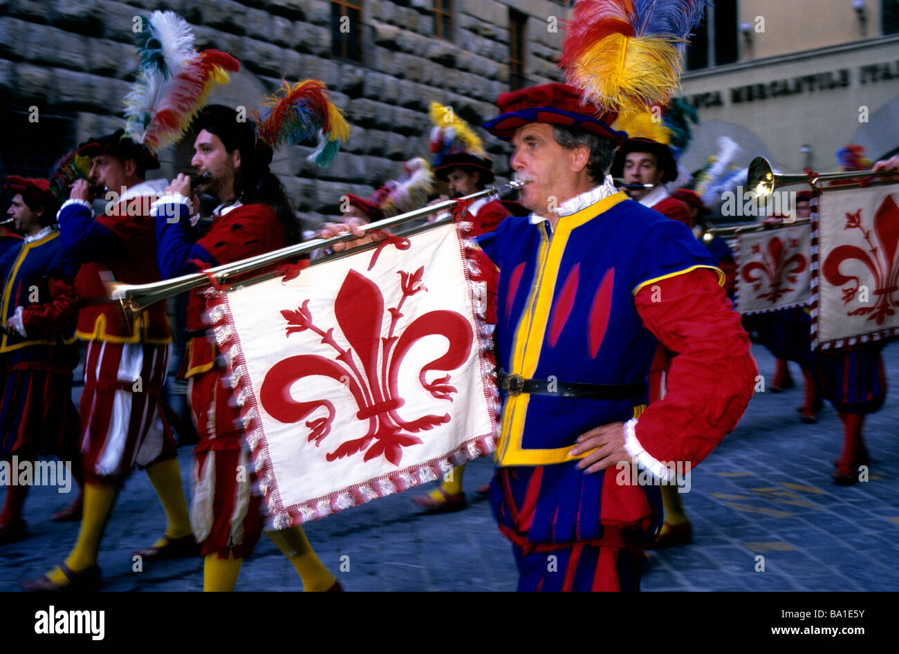 Un homme en uniforme traditionnel florentin jouant une longue trompette arborant symbolisme héraldique de lors d'un défilé à Florence Banque D'Images