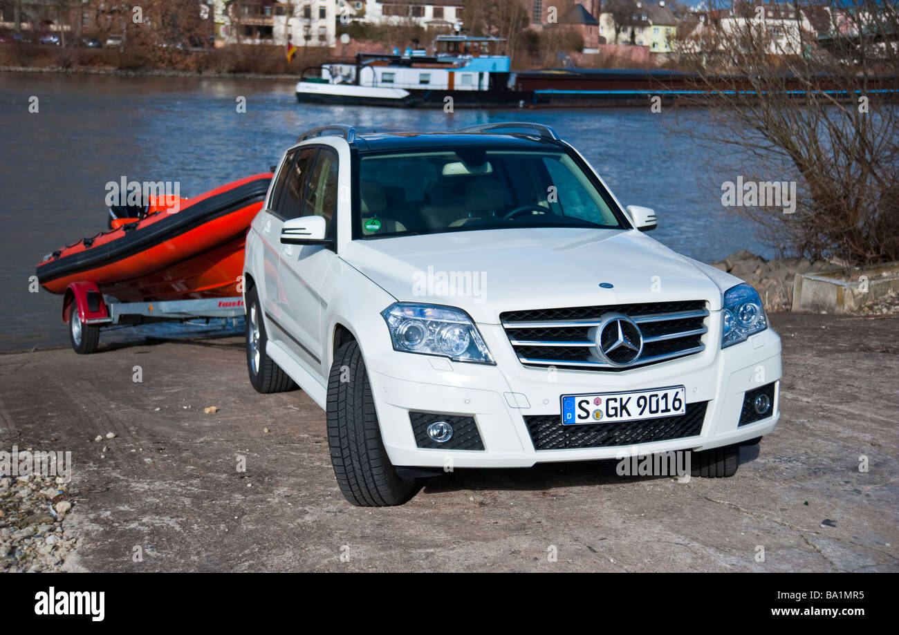 Mercedes GLK glisser bateau gonflable orange sur Rhin | Mercedes GLK slippt Schalauchboot orangenes Am Ufer des Rheins Banque D'Images