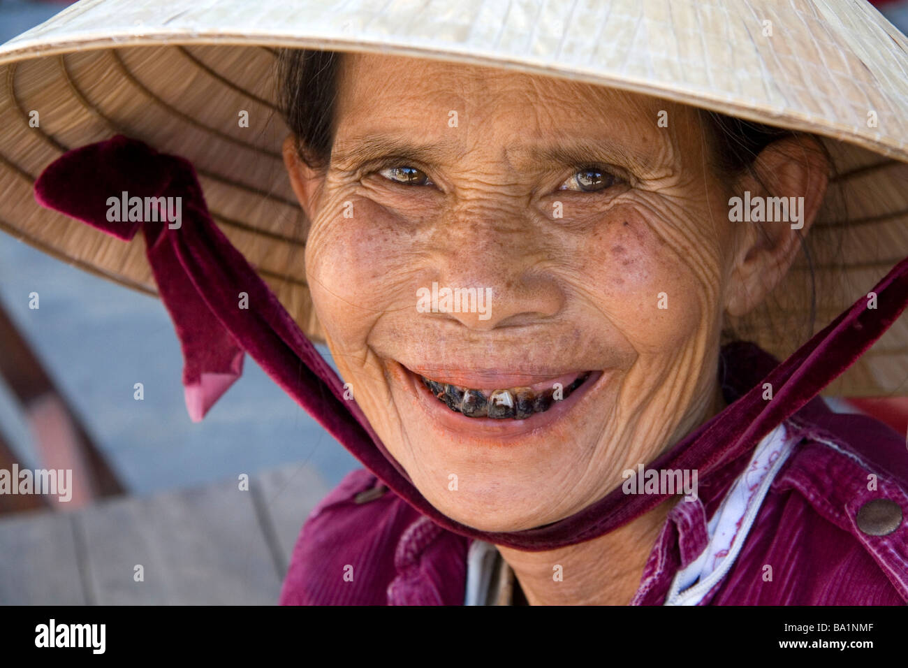 Portrait d'une vieille femme dont les Vietnamiens sont colorées des dents de beetle nut portant un chapeau traditionnel à Hoi An Vietnam Banque D'Images