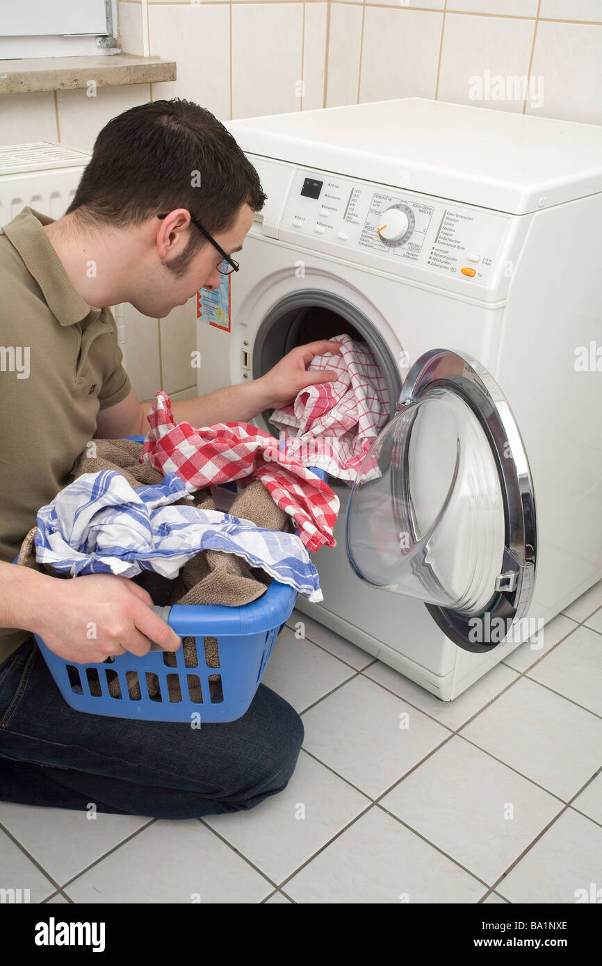 Jeune homme à la machine à laver Banque D'Images