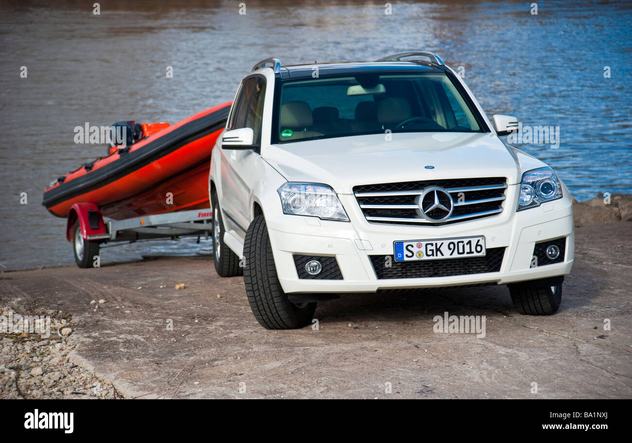 Mercedes GLK glisser bateau gonflable orange sur Rhin | Mercedes GLK slippt Schalauchboot orangenes Am Ufer des Rheins Banque D'Images