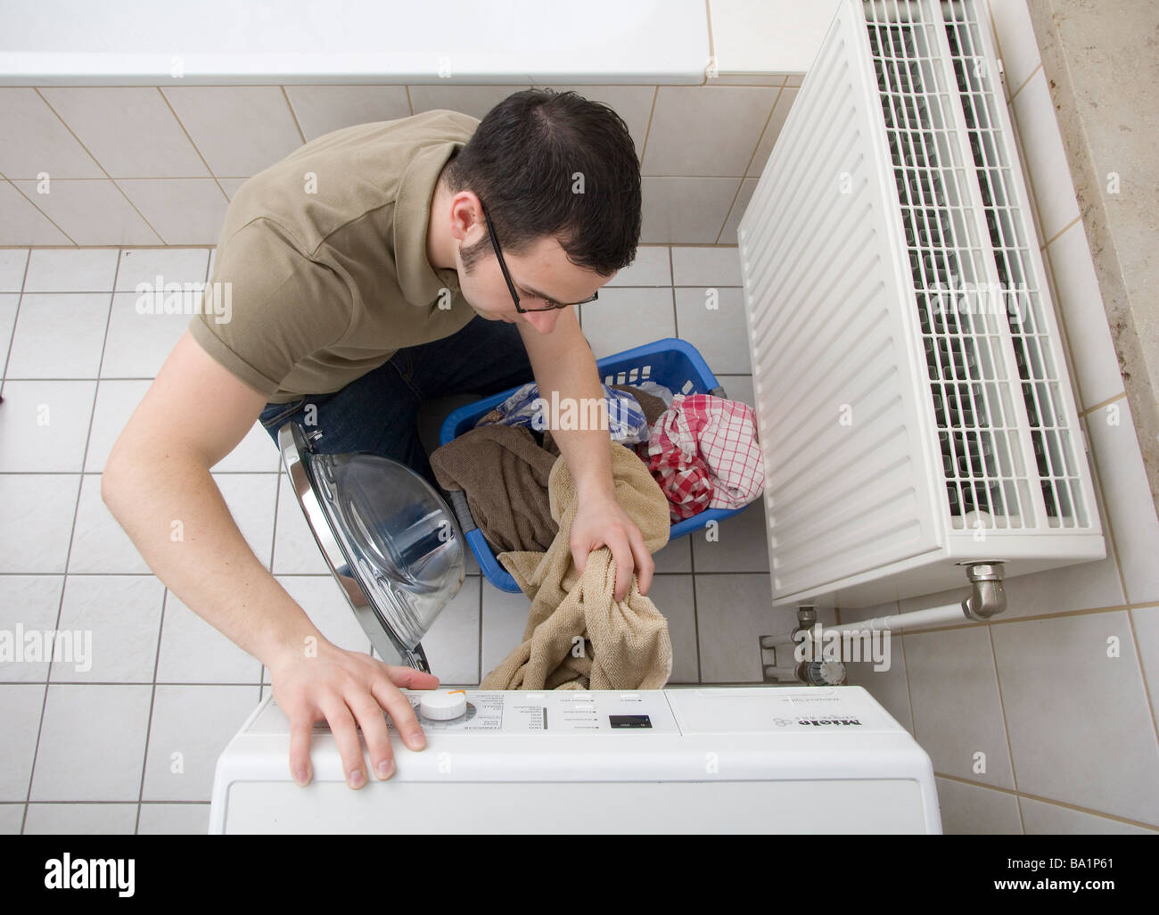 Jeune homme à la machine à laver Banque D'Images