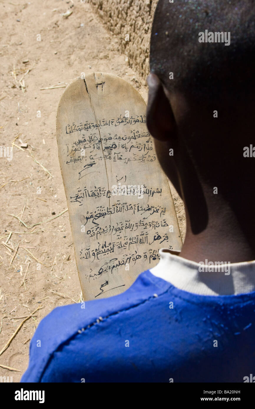 L'étude de l'Arabe garçon musulman sur une planche en bois dans la région de Djenné au Mali Banque D'Images