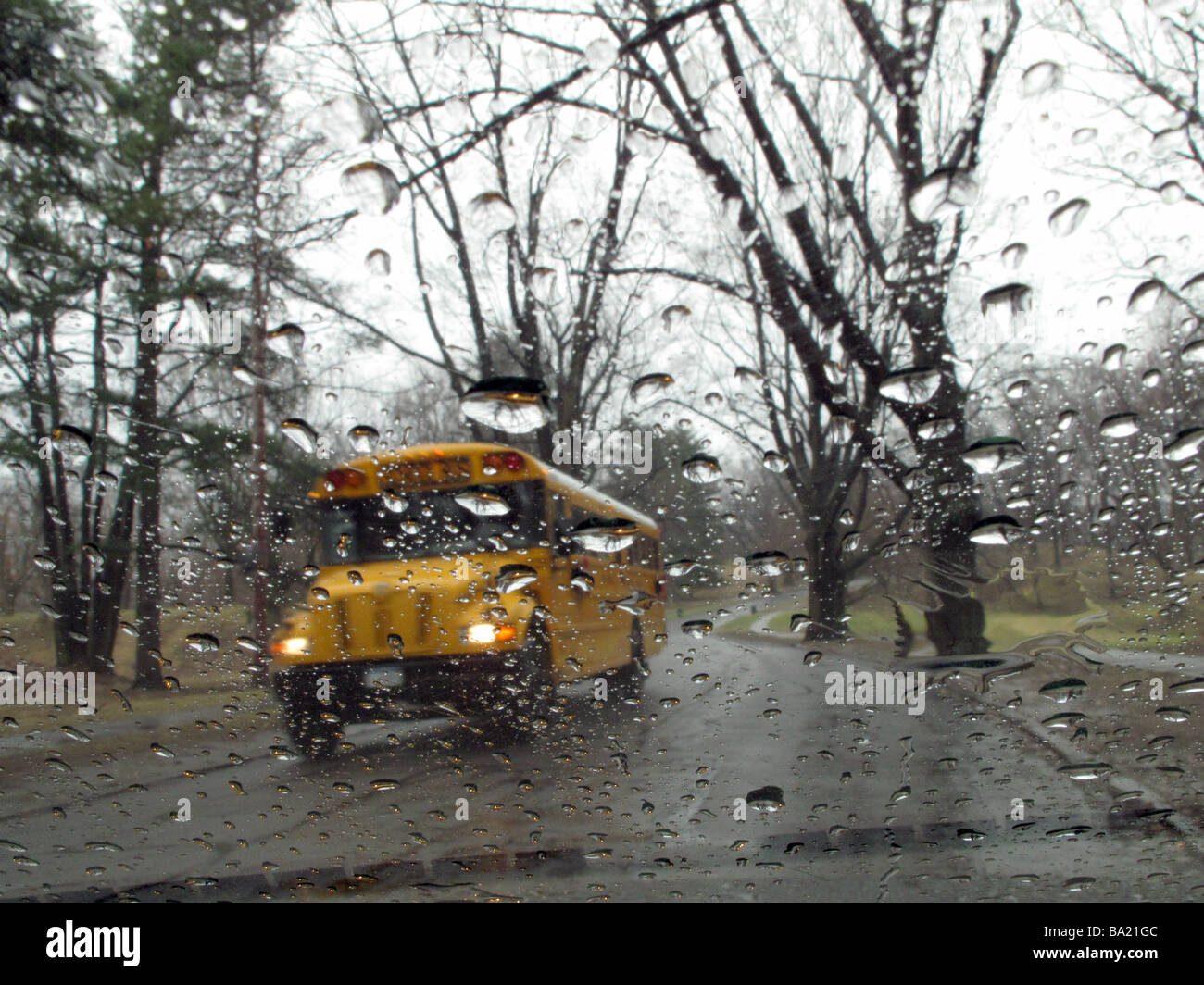 School bus venant en sens inverse sur un jour de pluie. Banque D'Images