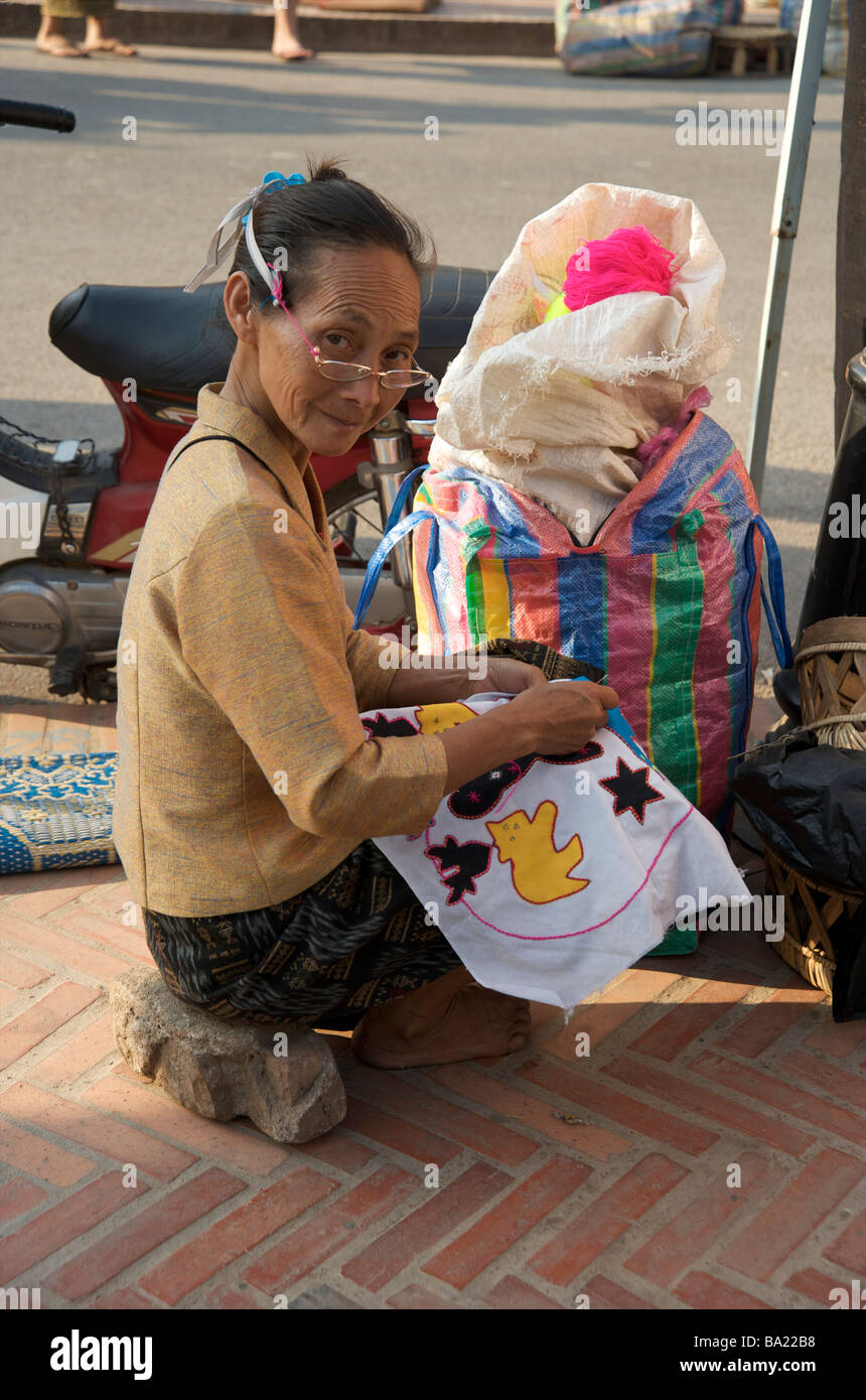 Une femme Lao une broderie couture en souvenir du marché de nuit de Luang Prabang au Laos Banque D'Images