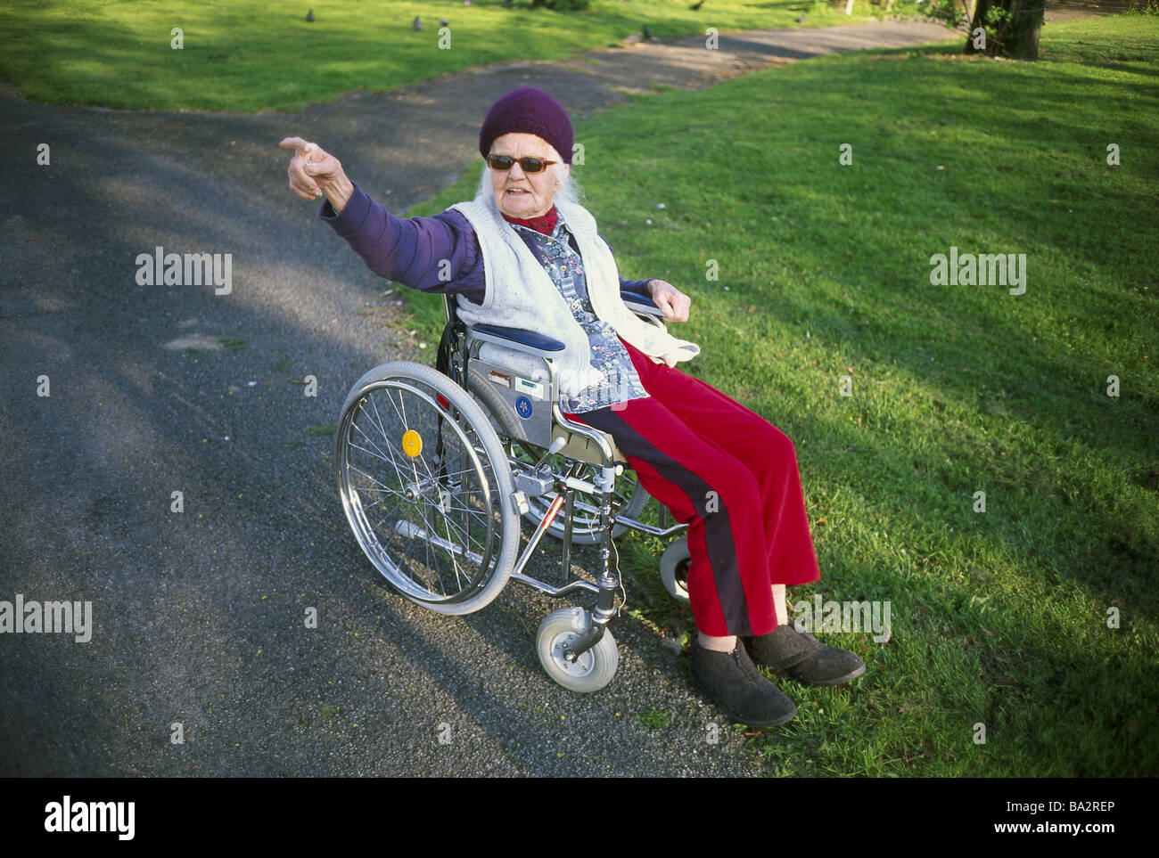 De 80 à 90 ans show park fauteuil roulant senior femme geste 90-100 ans 97 ans s'asseoir en verre soleil cap coiffure à pied de la vieillesse de l'air frais Banque D'Images