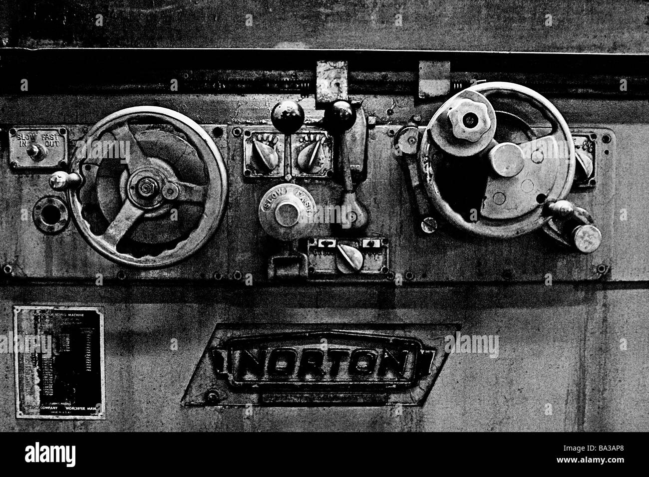 Image en noir et blanc d'antiques machines industrielles roues de contrôle et boutons de métal dans un atelier. Banque D'Images