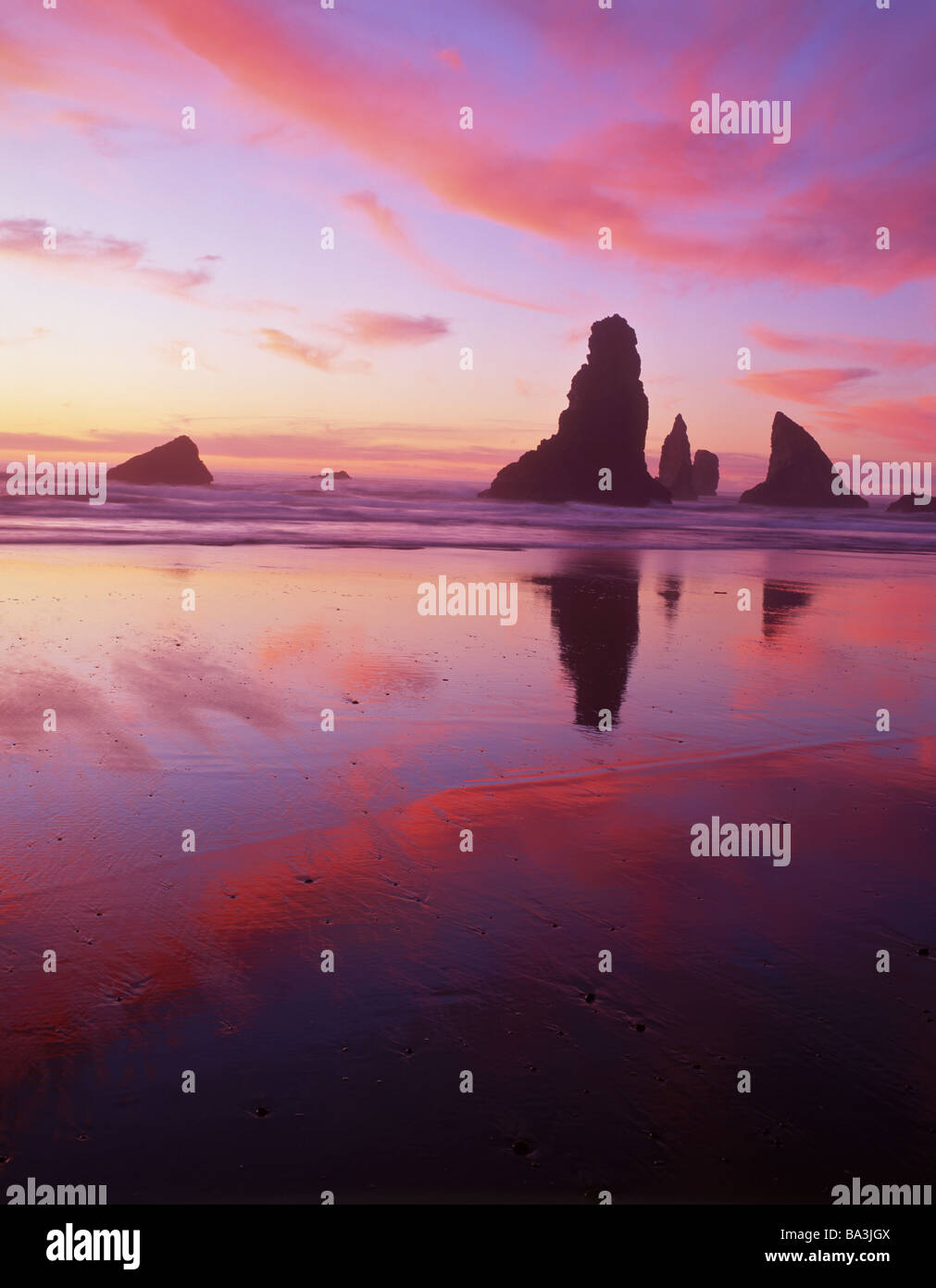 Fiery coucher du soleil la mer silhouettes stacks à l'Oregon's China Beach. Banque D'Images