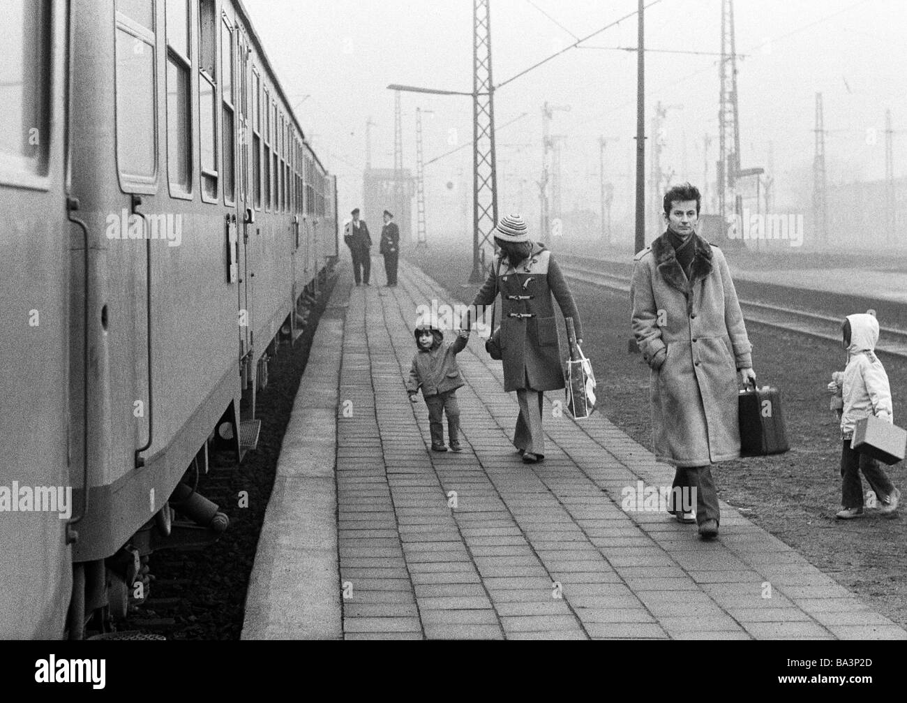 Années 70, photo en noir et blanc, le trafic ferroviaire, gare principale de Bottrop, jeune famille avec deux enfants est descendu du train et les promenades le long de la plate-forme à la sortie de la station, âgés de 25 à 40 ans, de 5 à 7 ans, de 2 à 3 ans, D-Bottrop, Ruhr, Rhénanie du Nord-Westphalie Banque D'Images