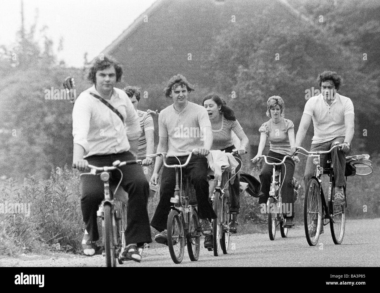 Années 70, photo en noir et blanc, le trafic routier, freetime, quatre jeunes hommes et deux jeunes femme en loisir aller sur un voyage en vélo, route de campagne, de 20 à 30 ans Banque D'Images